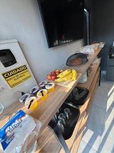 a counter with bananas apples and other fruits on it at Hotel Valle in Patrocínio