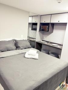 a bed with a white towel on top of it at Paradise Flat 104 in Nossa Senhora do Livramento