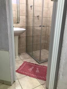 a bathroom with a shower and a rug on the floor at Pousada Encantos de Paripueira in Paripueira