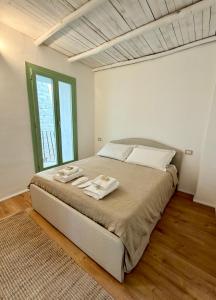 a bedroom with a large bed with towels on it at AbalabÀ - Gallura Retreat - Domo in Aggius +7 photos