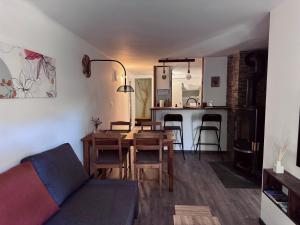 a living room with a table and chairs and a kitchen at Csöpi Apartman Tapolca in Tapolca