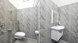 a bathroom with a shower and a toilet and a sink at Golden Spoon in Jāmb