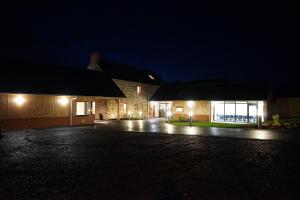 an empty parking lot in front of a building at night at La Cocotte Gourmande in Carantilly