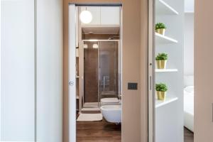 Duomo Apartments B Home - Panoramic Two Bedrooms Apt في ميلانو: حمام مع مرحاض وحوض استحمام