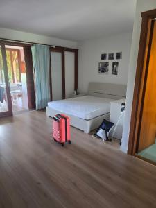 1 dormitorio con 1 cama y 1 maleta en el suelo en Bilocale Levante G3, en Porto Rotondo