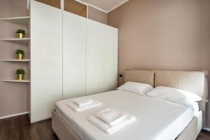 Duomo Apartments B Home - Panoramic Two Bedrooms Apt في ميلانو: غرفة نوم بسرير أبيض ووسائد بيضاء