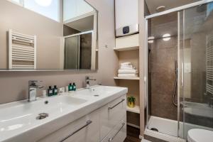 Duomo Apartments B Home - Panoramic Two Bedrooms Apt في ميلانو: حمام مع حوض ودش