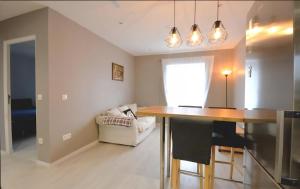 a kitchen and living room with a table and a couch at Appartement proche Walibi in Les Avenières