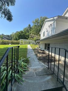 a house with a fence next to a sidewalk at 5 Min walk to Stony Brook University in Stony Brook
