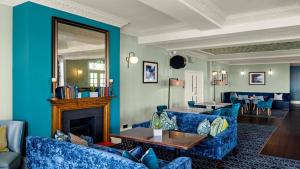 a living room with blue furniture and a fireplace at Kingscliff, BW Signature Collection in Clacton-on-Sea +116 photos