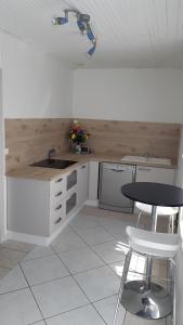 a kitchen with a counter and a table and chairs at Maison de la mer in Brétignolles-sur-Mer