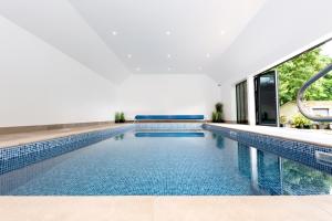 een binnenzwembad met blauwe tegels in een gebouw bij Meadow View House at Pudleston Court in Docklow