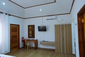 een kamer met een bureau en een televisie aan de muur bij La Maison Figaro Guest House in La Réunion