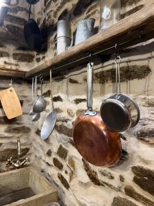 a bunch of pots and pans hanging on a wall at il Bosco in Roccaforte Mondovì +86 photos