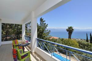 a balcony with a table and two chairs and the ocean at Villa Cleo in Kalamaki