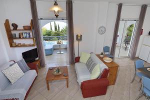 a living room with a couch and a table at Villa Cleo in Kalamaki