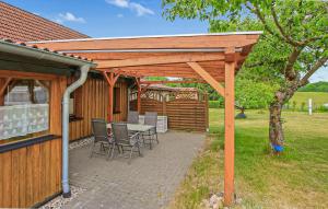 a wooden pergola with a table and chairs on a patio at Ferienwohnung Zislow in Zislow
