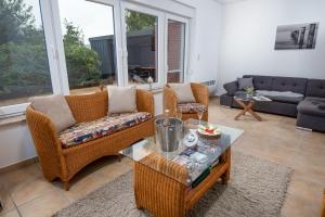 a living room with wicker chairs and a table at Seewind in Krummhörn