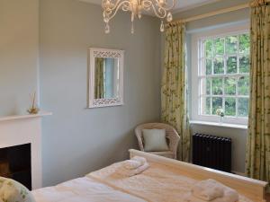 a bedroom with a bed and a fireplace and a chandelier at Starry Cottage in Bakewell