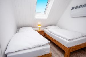 two beds in a small room with a window at Seewind in Krummhörn
