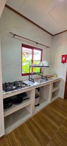 a kitchen with a stove and a window at La Maison Figaro Guest House - Spacious Island Stay in La Digue in La Réunion +25 photos
