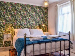 a bedroom with a bed with a floral wallpaper at The Sandpiper in Filey +12 photos