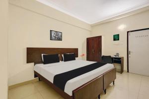 a bedroom with a large bed with a desk and a desk at Super Collection O jagadamba Junction near Beach Road in Visakhapatnam