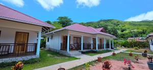 een rij huizen met een berg op de achtergrond bij La Maison Figaro Guest House in La Réunion