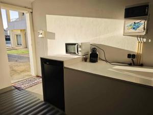 a kitchen with a counter with a microwave on it at GuestHouse Relax & Pool in Esmoriz