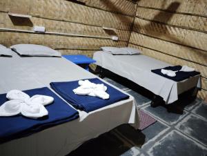 two beds sitting next to each other with towels on them at Anu Guest House in Hampi