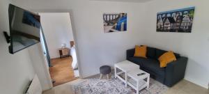 a living room with a blue couch with yellow pillows at Appartement lumineux -terrasse au cœur de Morlaix in Morlaix