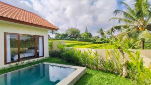 a villa with a swimming pool and a garden at The Swasti Villa Ubud in Tegalalang
