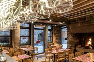 a restaurant with tables and chairs and a fireplace at La Confiance in Le Mont Saint Michel