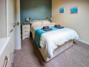 a bedroom with a bed with two towels on it at May Cottage in Hackness +4 photos