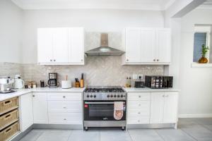 een keuken met witte kasten en een fornuis bij Mirari in Oudtshoorn