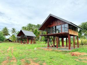 a house that is sitting in a field at Kolla Watersong Resort in Sigiriya