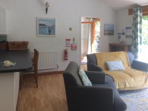 a living room with two chairs and a couch at Oaktree Cottage in Appledore