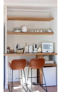 two chairs sitting in front of a shelf at Le Goëland, chambre d'hôtes, avec coin repas équipé, SDB privée, 20m2, jardin, piscine, vélos, proche mer in Les Lecques