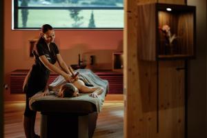 a woman getting a massage from a woman laying on a bed at Hotel Masl in Valles
