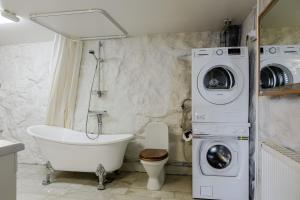 bagno con vasca e lavatrice. di Lakefront Getaway in Hagaparken Central Stockholm a Stoccolma