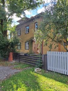 a house with a white fence in front of it at Avar ja mugav korter kesklinna lähedal in Tartu