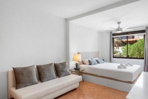 a bedroom with a bed and a couch at MEDANO4YOU Montaña Roja Beach House in El Médano