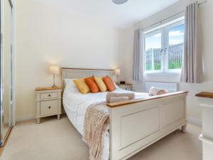 a bedroom with a bed with orange pillows and a window at Kincraig Apartment in Inshes