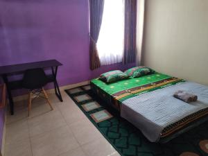 ein Schlafzimmer mit einem Bett und einem Tisch und einem Fenster in der Unterkunft Omah Semaki in Demangan