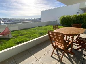 a wooden table and chairs sitting on a balcony at Appartement au face port avec grande terrasse in Audierne +24 photos