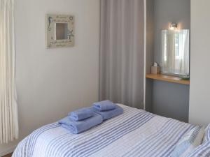 un letto con due asciugamani blu sopra di Cottage By The Sea a Bacton Altre 22 foto