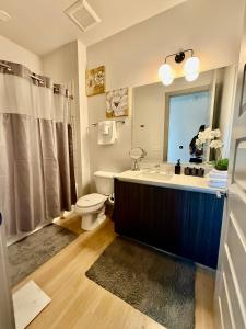 a bathroom with a sink and a toilet and a mirror at Modern luxury at the Interlock in Atlanta