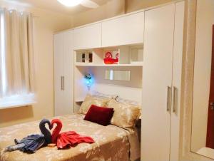 un dormitorio con dos cisnes sentados en una cama en AP Top na Praia da Costa, en Vila Velha