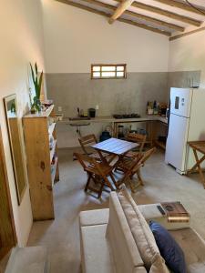 Una sala de estar con un sofá y una mesa y una cocina. en Casa e Chalé raio de sol, en Caraíva