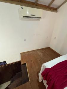 an empty room with a bed and a air vent at Casa e Chalé raio de sol in Caraíva